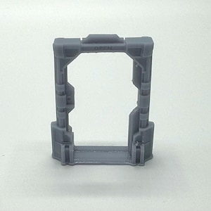 May include: A grey plastic model of a doorway with the word "OPEN" printed on the top. The doorway is made of a series of rectangular panels.