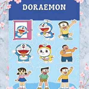 May include: A blue and white Doraemon-themed sticker sheet featuring various cartoon character illustrations. The word "DORAEMON" is displayed in white block letters at the top. The sheet is decorated with pink floral accents.