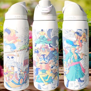 May include: White insulated water bottle featuring colorful anime-style illustrations of characters. The bottle has a white lid with a push-button opening and the brand name "owala" printed on the side. The illustrations include various characters in action poses.