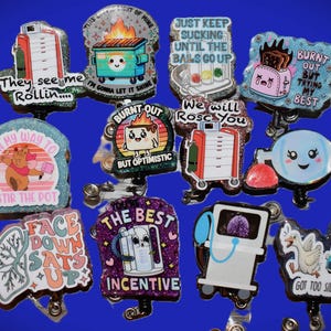 K&ouml;nnte beinhalten: Eine Sammlung glitzernder Ausweisrollen mit verschiedenen Designs und Texten. Die Designs umfassen einen M&uuml;llcontainer mit Flammen, einen Toaster, einen B&auml;ren, der einen Topf umr&uuml;hrt, und medizinische Ger&auml;te. Texte sind "They see me Rollin...", "Burnt Out" und "The Best Incentive."