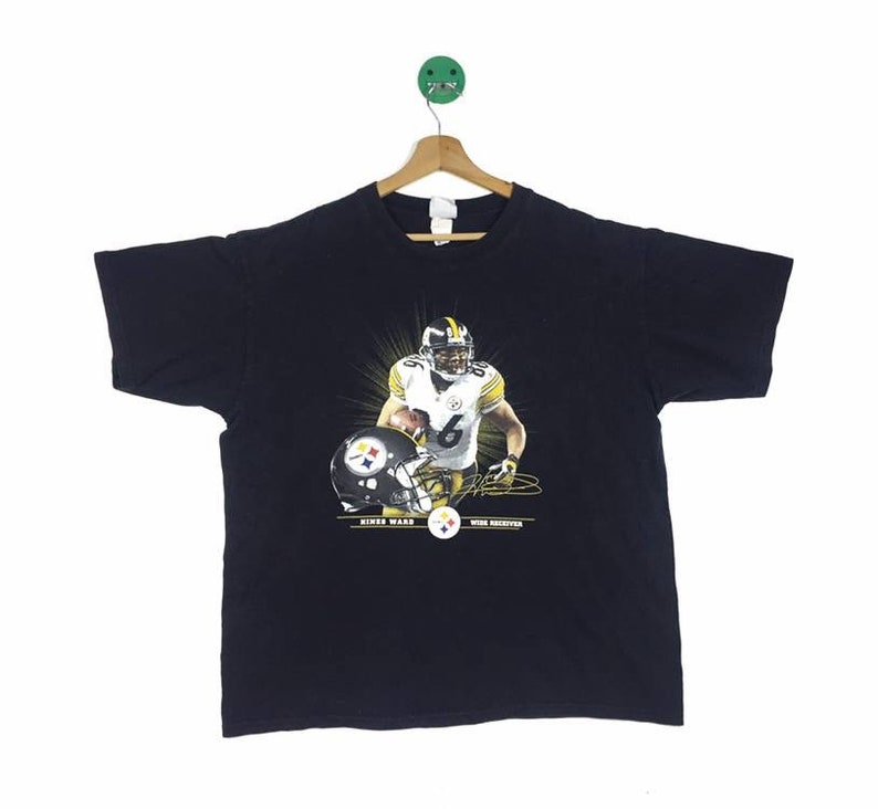 K&ouml;nnte beinhalten: Schwarzes T-Shirt mit einem Grafikdruck von Hines Ward, einem Wide Receiver der Pittsburgh Steelers, der ein schwarz-gelbes Trikot tr&auml;gt. Die Grafik enth&auml;lt seine Unterschrift und den Text "Hines Ward" und "Wide Receiver".