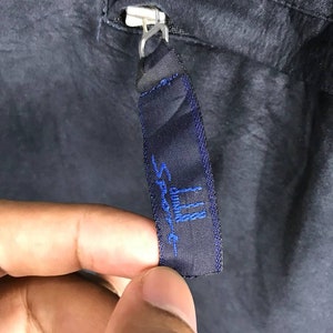 May include: A black zipper pull with a blue embroidered label that reads "Sport III".