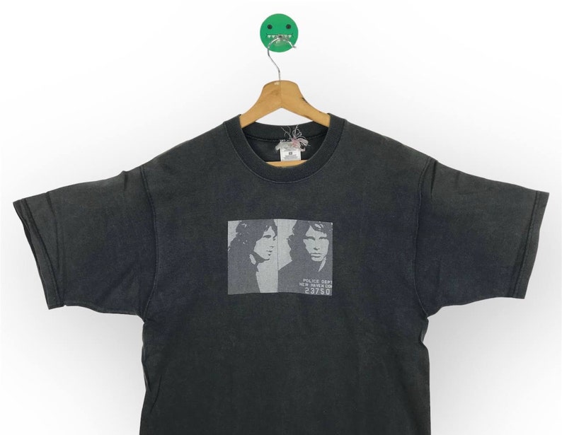 Puede incluir: Camiseta negra con un estampado descolorido de dos caras de hombres y el texto "Police Dept. New York City 23750".