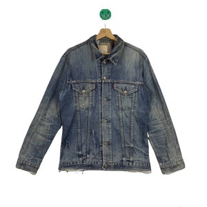 May include: A blue denim jacket with a button closure, two chest pockets, and two front pockets. The jacket has a faded and distressed look.