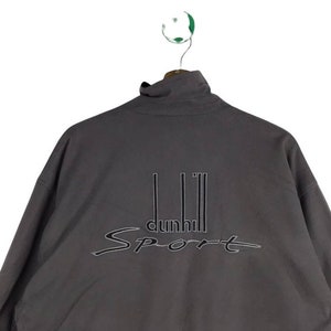 May include: A gray zip-up jacket with the text "dunhill Sport" embroidered on the back.