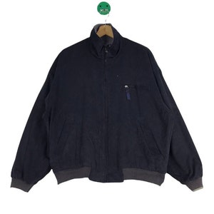 May include: A dark blue zip-up jacket with a zippered pocket on the left side.