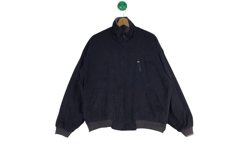 May include: A dark blue zip-up jacket with a zippered pocket on the left side.