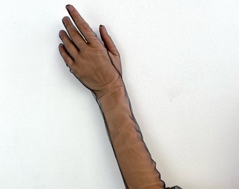 May include: Black sheer gloves reaching the upper arm. The gloves are crafted from a delicate, see-through material. The design includes seams that follow the hand and arm's shape, providing a fitted appearance. The gloves are a solid black colour.