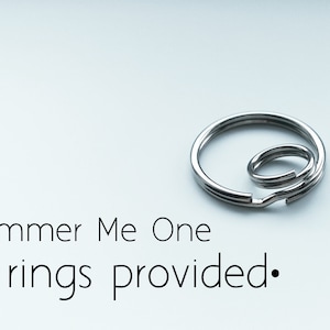 Puede incluir: Dos anillos partidos plateados, uno m&aacute;s grande que el otro, se muestran sobre un fondo blanco. El texto "Hammer Me One" y ".split rings provided." est&aacute; debajo de los anillos.