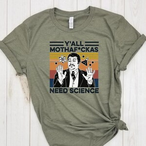 Peut inclure: Un t-shirt vert avec un graphique rétro de Bill Nye le Science Guy. Le graphique présente le texte "Y'all Mothaf*ckas Need Science" avec un schéma de couleurs vintage.