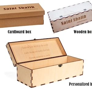 May include: Three wooden boxes with different designs. The first box is made of cardboard and has the text "Saint Shalih" printed on it. The second box is made of wood and has the text "Saint Shalih" printed on it. The third box is made of wood and has a personalized message engraved on the lid. The box is open and the inside is visible.
