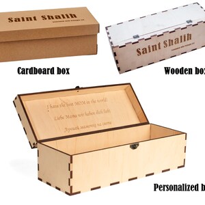 May include: Three wooden boxes with different designs. The first box is made of cardboard and has the text "Saint Shalih" printed on it. The second box is made of wood and has the text "Saint Shalih" printed on it. The third box is made of wood and has a personalized message engraved on the lid. The box is open and the inside is visible.