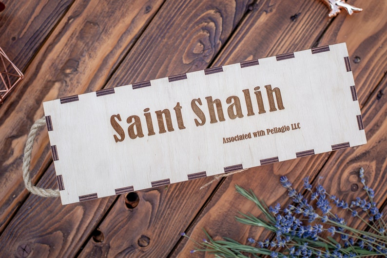 May include: A wooden box with a rope handle. The box is labeled "Saint Shalish" and "Associated with Pellaglo LLC".