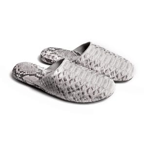 May include: A pair of gray and white snake skin slippers. The slippers are made of soft, supple leather and have a comfortable fit.