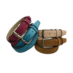 May include: Three suede belts in different colors: burgundy, teal, and beige. Each belt has a silver buckle.
