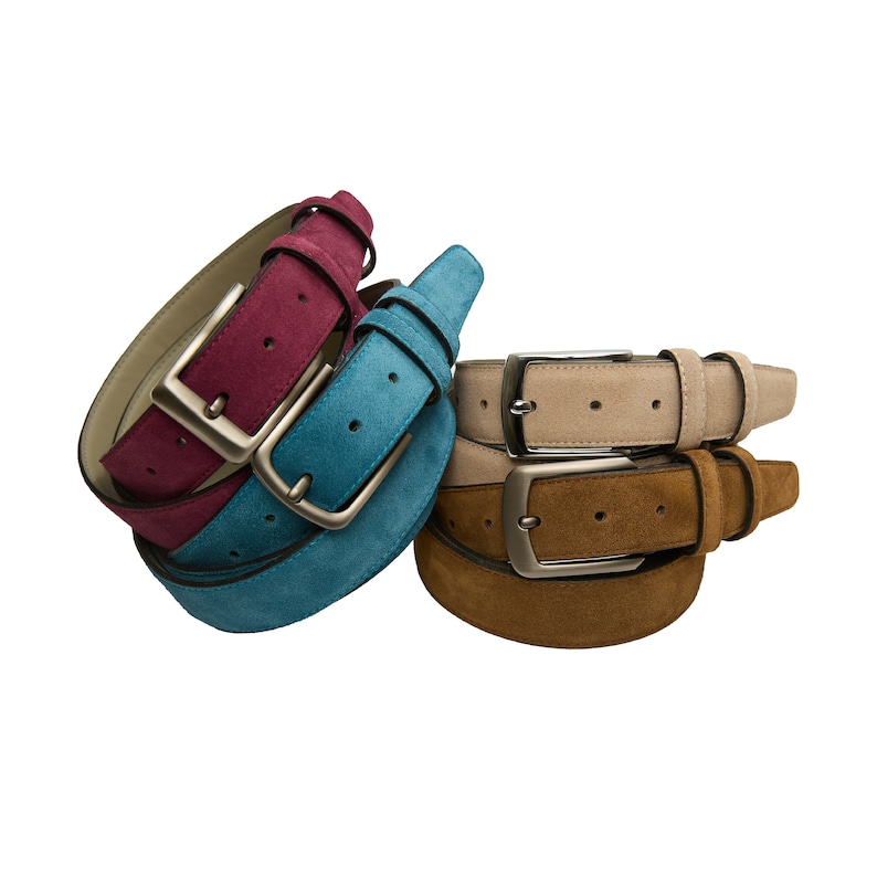 May include: Three suede belts in different colors: burgundy, teal, and beige. Each belt has a silver buckle.