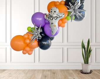 May include: A Halloween balloon garland featuring orange, purple, and black balloons, with a ghost-shaped balloon that says "BOO". The garland is decorated with black and white checkered starbursts, perfect for a festive party.