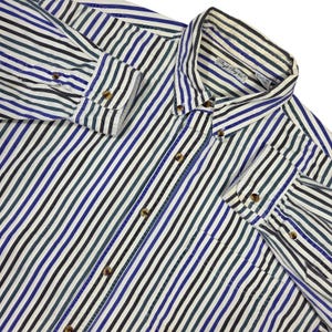 May include: A button-down shirt with vertical stripes in white, black, blue, and green. The long-sleeved shirt has a button-down collar and buttoned cuffs. The shirt is made of a lightweight fabric.