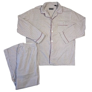 May include: A two-piece pajama set in a checkered pattern. The top has a button-down front, a chest pocket, and burgundy trim on the collar, cuffs, and pocket. The pants have an elastic waistband. The pajamas are made of a soft, lightweight fabric.