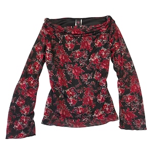 May include: A long-sleeved top with a black background and a vibrant red floral pattern. The top features a cowl neckline and flared sleeves. The fabric appears to be semi-sheer, with a delicate texture. The top has a fitted silhouette.