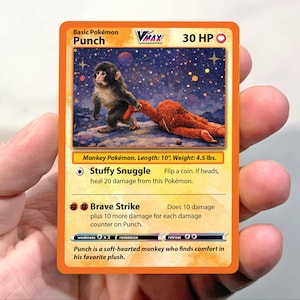 May include: A white ceramic mug with a black handle and the text "But First, Coffee" in a bold, black font. The mug is set against a blurred background, suggesting a cozy setting. The mug appears to be approximately 4 inches tall.