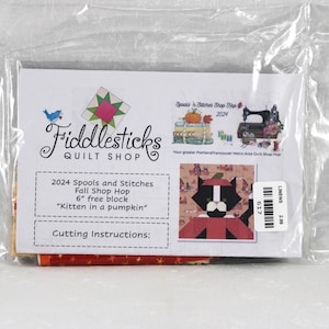 May include: A Fiddlesticks Quilt Shop 2024 Spools and Stitches Fall Shop Hop kit in a clear plastic bag. The label features a kitten in a pumpkin graphic, the text 2024 Spools and Stitches Fall Shop Hop 6 inch free block, and cutting instructions.