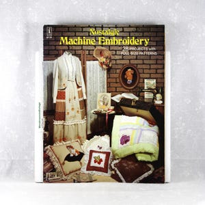 May include: A softcover book titled Nostalgic Machine Embroidery with 28 projects and full-size patterns. The cover features a brick wall background displaying a mannequin in a patchwork dress, a quilt, and several embroidered pillows with designs.