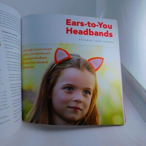 May include: A book cover with a photo of a young girl wearing a headband with orange felt ears. The title of the book is "Ears-to-You Headbands" with the designer's name, Laura Howard, listed below. The text on the page reads "All it takes is some scraps of felt, a few stitches, and a purchased headband to make these whimsical animal ears."