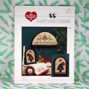 Vintage 1985 Need'l Love Co. "Happy Holly Deers" autorstwa Renee Nanneman, Ulotka do haftu krzyżykowego nr L4-HD, 5 wzorów/projektów z reniferami i Mikołajem