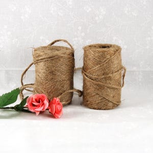 May include: A white ceramic mug with a black handle and the text "But First, Coffee" in a black, bold font. The mug is on a white surface.