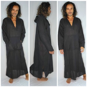 May include: Black hooded robe with a V-neck and long sleeves. The robe has a front pocket and a long, flowing design. The fabric appears to be lightweight and suitable for warm weather. The robe is shown from multiple angles.