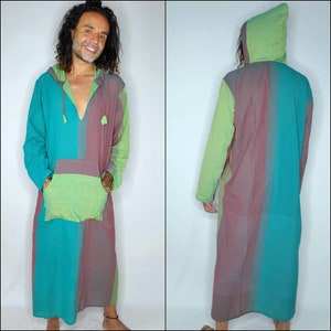 May include: A long-sleeved hooded tunic with a patchwork design in shades of green, blue, and pink. The tunic has a v-neck and a kangaroo pocket.