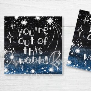 May include: Two square cards with a starry night design. The cards have a dark blue and black gradient background with white stars and the text "You're out of this world". The cards have a watercolor effect.