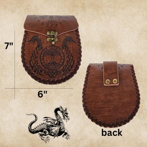 May include: Brown leather pouch with a flap closure and a brass buckle. The pouch is decorated with a tree of life design, a dragon, and runes. The pouch measures 7 inches tall and 6 inches wide. The back of the pouch is plain brown leather.