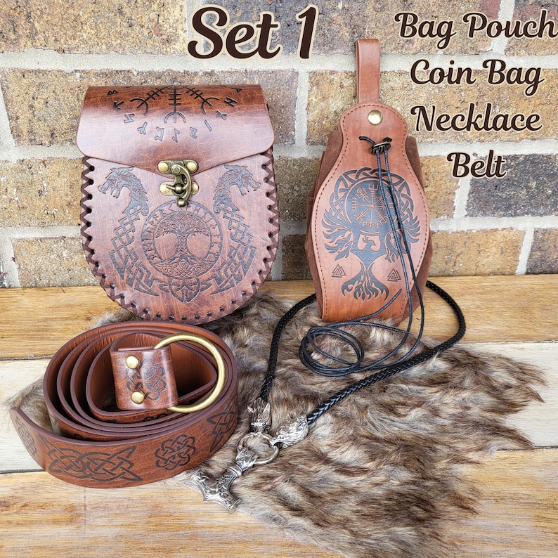 May include: Set of four brown leather accessories with Viking-inspired designs. The set includes a bag pouch, a coin bag, a necklace, and a belt. The accessories are decorated with intricate carvings of trees, runes, and other symbols.