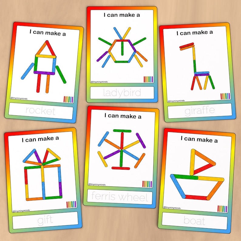 May include: Six colorful cards with rainbow borders. Each card has a picture of a simple object made from colorful sticks. The cards have the words "I can make a" and the name of the object written below the picture. The objects are a rocket, a ladybug, a giraffe, a gift, a ferris wheel, and a boat.