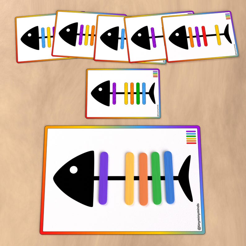 K&ouml;nnte beinhalten: Eine druckbare Fischskelett-Zuordnungsaktivit&auml;t mit einem Regenbogen-Farbschema. Die Aktivit&auml;t beinhaltet ein gro&szlig;es Fischskelett mit leeren Stellen f&uuml;r die regenbogenfarbenen Knochen und sechs kleinere Fischskelette, bei denen die regenbogenfarbenen Knochen bereits vorhanden sind.