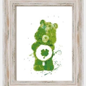 Pode incluir: Impressão emoldurada de um urso verde com um trevo branco na barriga. O urso é retratado em um estilo pixelizado, com diferentes tons de verde. A moldura é branca.