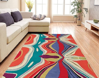 May include: Abstract area rug with a colorful, wavy pattern in shades of red, blue, green, yellow, and purple. The rug has a modern, contemporary design.