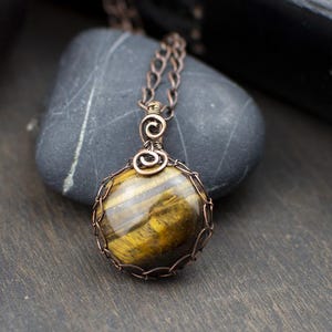 Tigerauge und gealterter Kupferanhänger — Schutz, Mut, Hellsehen