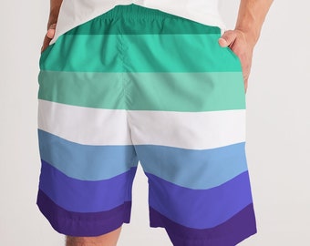 May include: A pair of men's swim trunks with a horizontal striped pattern in shades of green, blue, and purple. The stripes are reminiscent of the LGBTQ+ pride flag.