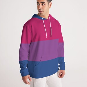May include: A pink, purple, and blue striped hoodie with a white drawstring.