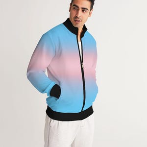 Puede incluir: Una chaqueta bomber azul y rosa degradada con cremallera negra y cuello y puños de canalé negros.