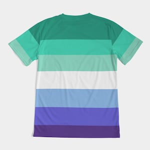Puede incluir: Una camiseta de manga corta con un patr&oacute;n de rayas horizontales en tonos de verde, blanco, azul y morado. La camiseta tiene cuello redondo.