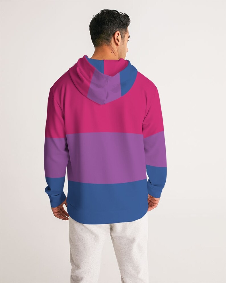 May include: A pink, purple, and blue striped hoodie with a drawstring hood. The hoodie is made of a soft, comfortable material and has a relaxed fit.