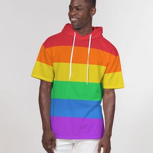 May include: A short-sleeved hooded shirt with a rainbow pattern. The shirt has a relaxed fit and a drawstring hood.