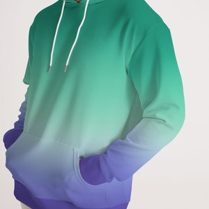May include: A green and purple ombre hoodie with a drawstring hood and kangaroo pocket.