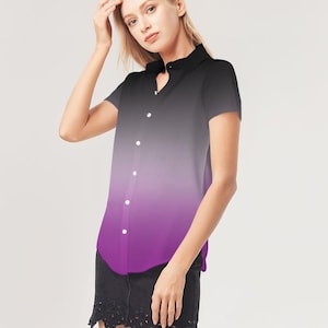 May include: Short-sleeved button-down shirt with a gradient design. The shirt transitions from black at the top to purple at the bottom. It features a classic collar and white buttons. The shirt is worn with a black skirt.
