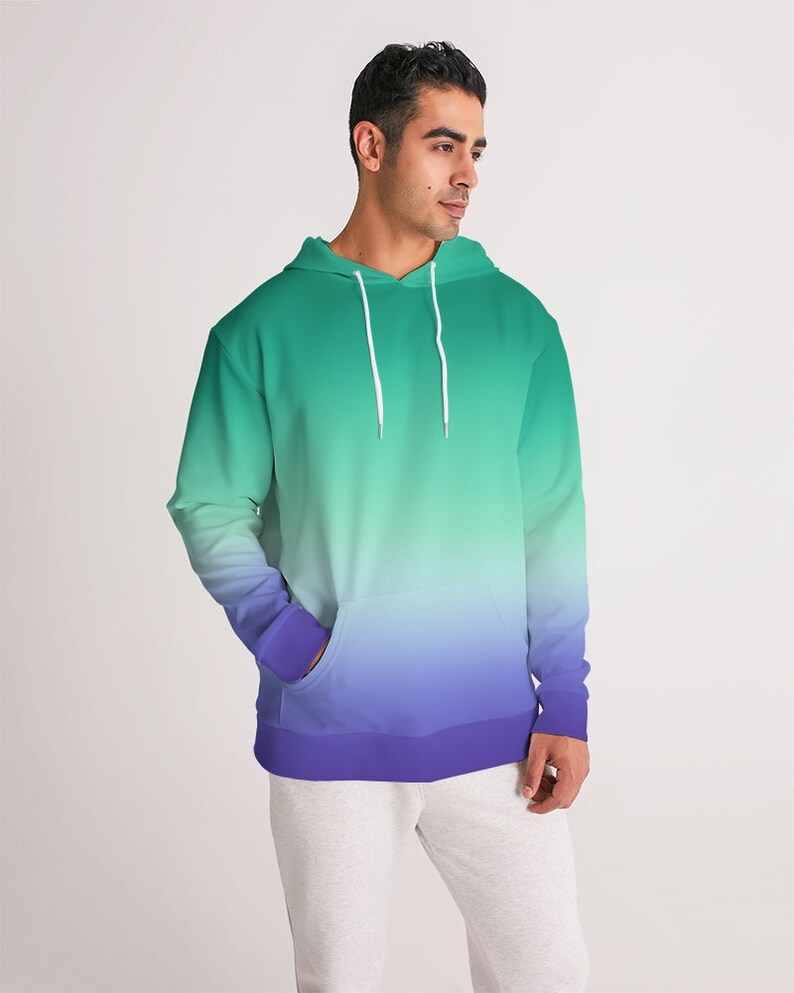 May include: A green and purple ombre hoodie with a drawstring hood. The hoodie has a kangaroo pocket and a ribbed hem.
