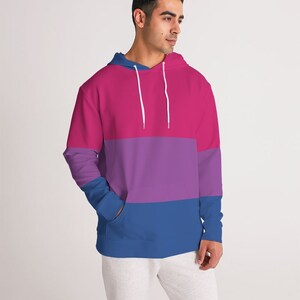 May include: A pink, purple, and blue striped hoodie with a drawstring hood.